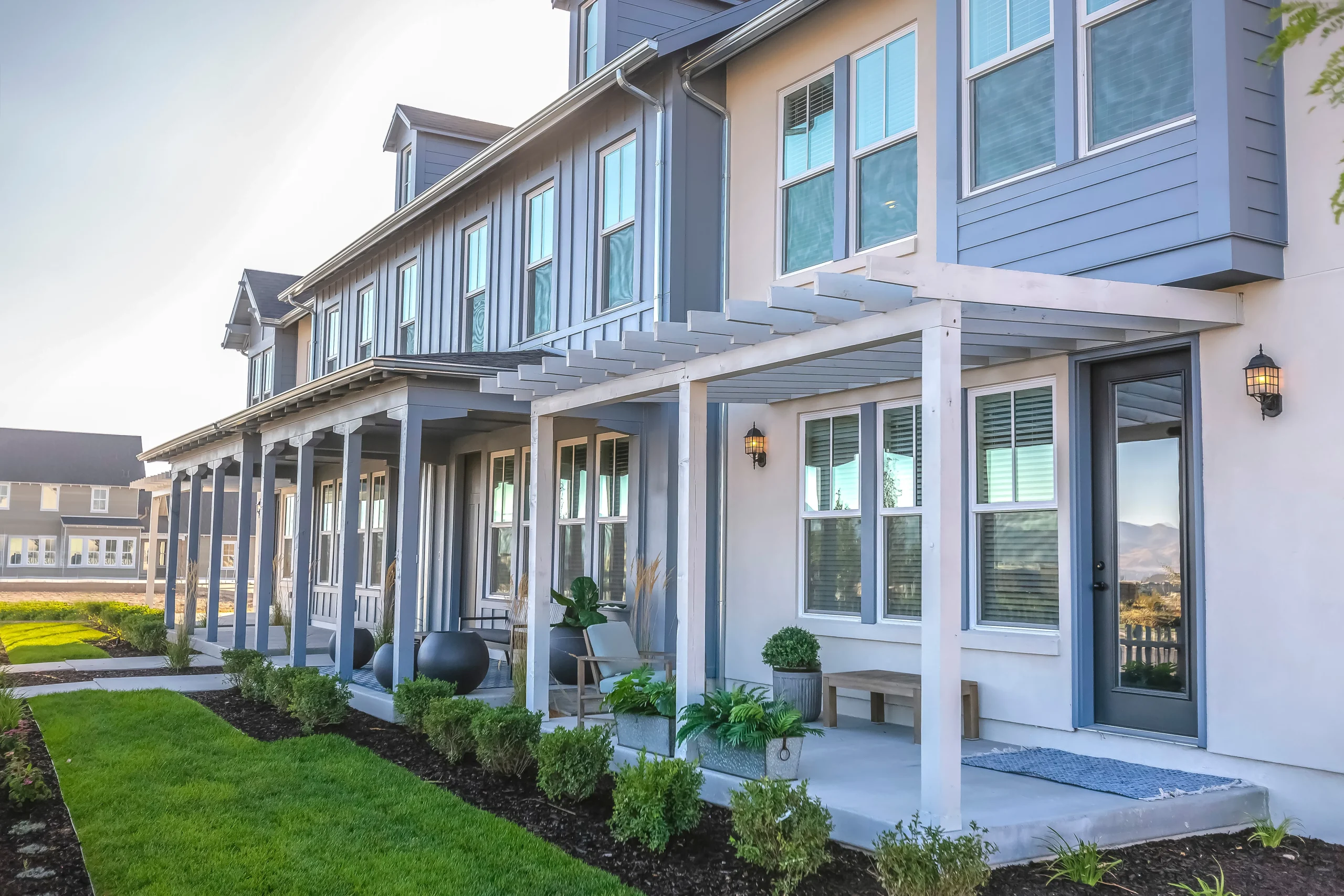 Row of modern townhomes with covered front porches and landscaped yard