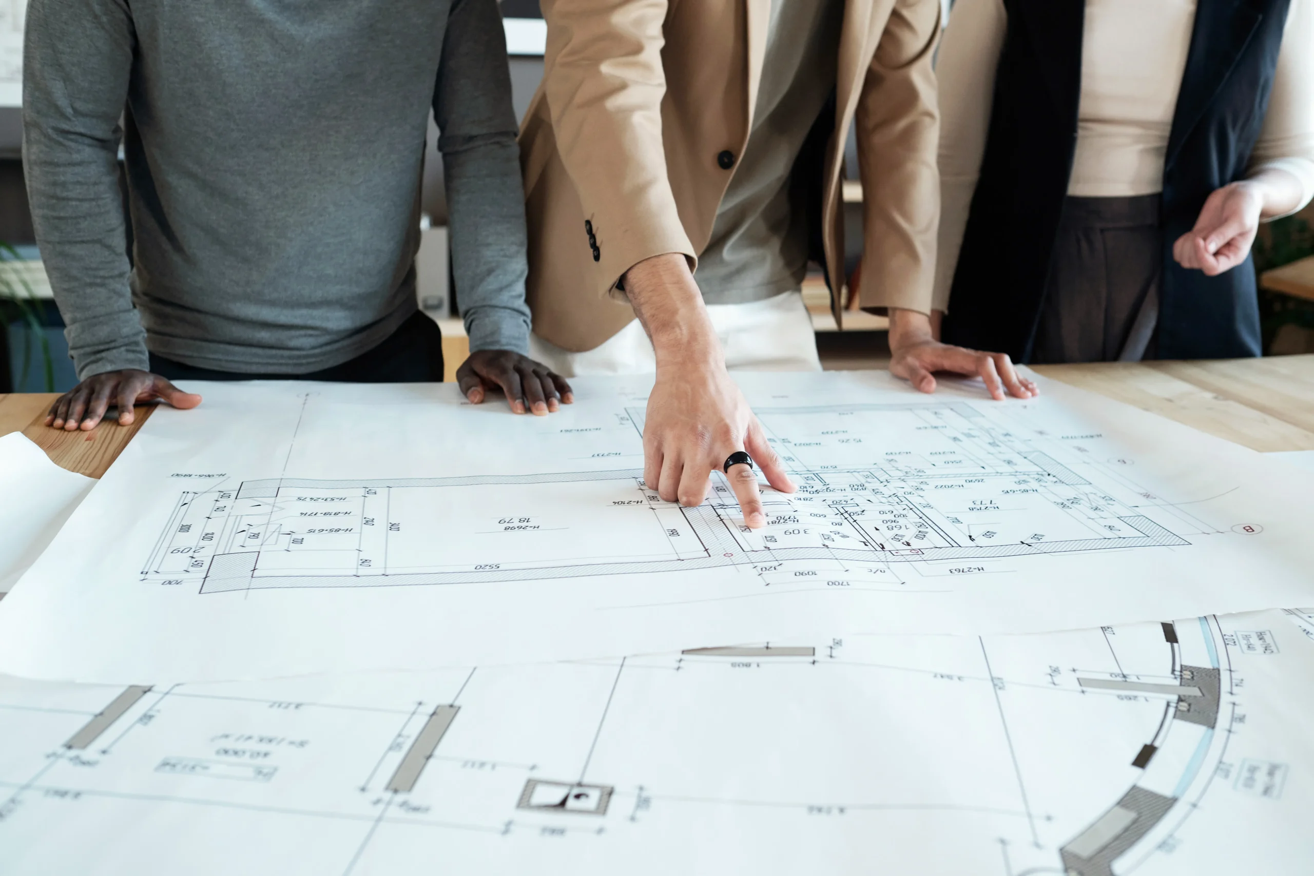Team reviewing architectural floor plans on a table