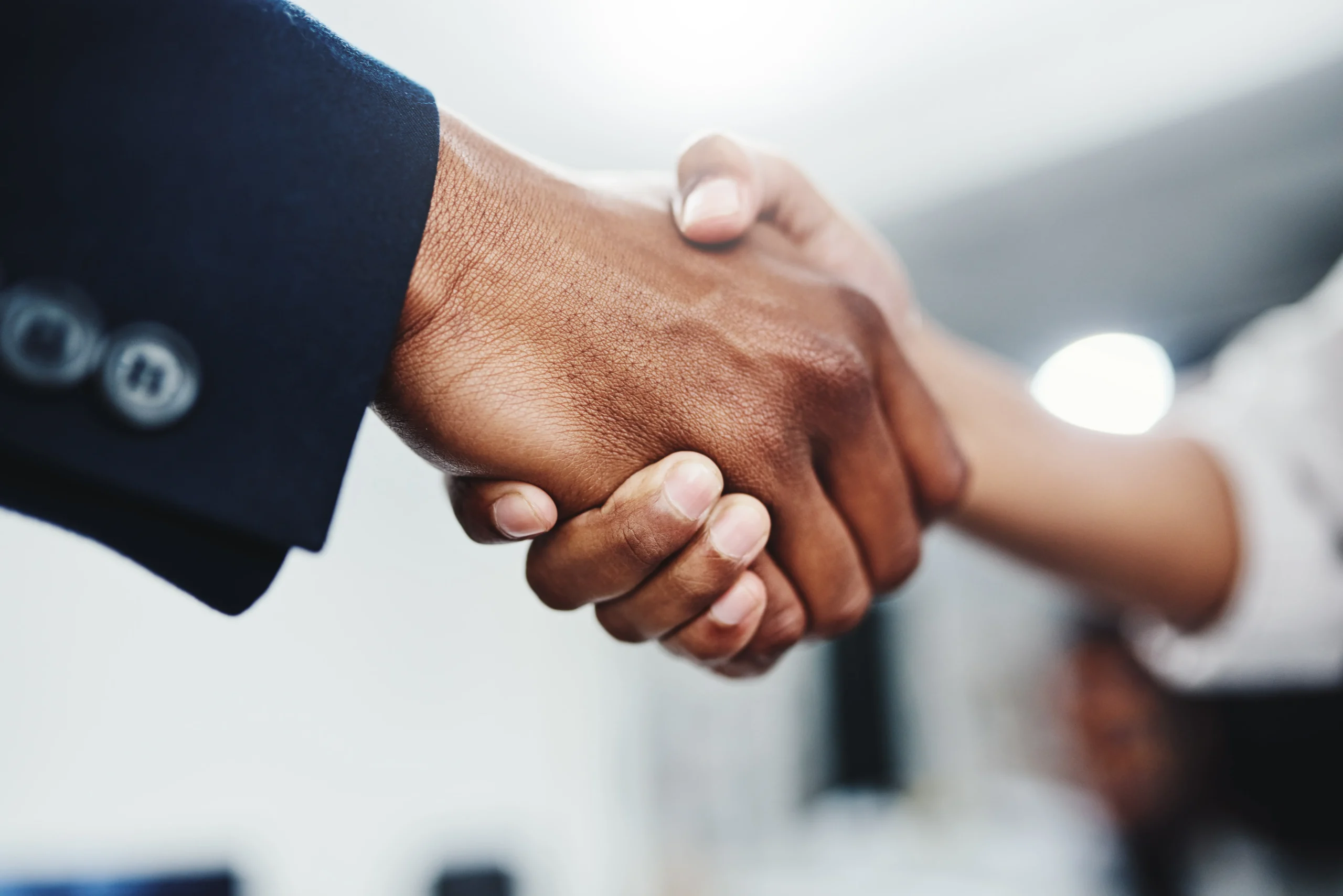 Close-up of two people shaking hands, symbolizing agreement, partnership, or a successful deal.